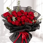 دسته گل شیدا با رز قرمز و بسته‌بندی مشکی شهرگل